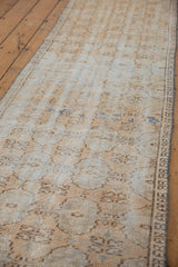 Distressed vintage Oushak runner, faded floral guls, worn texture, ivory, beige, and subtle blue.