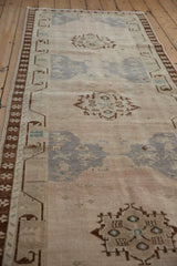 Distressed Oushak runner texture, showing faded royal blue and coffee brown geometric motifs.