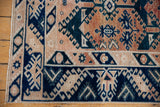 Distressed vintage Oushak rug corner, indigo blue geometric gul motifs, and pale terracotta.