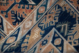 Vintage distressed Oushak rug's folded edge, showcasing indigo, terracotta gul, and hook motifs.