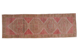 Vintage Distressed Oushak runner with interconnected geometric medallions in dusty raspberry, beige, and pale sage.
