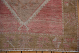Distressed Oushak runner, fringed edge with geometric floral in faded raspberry and beige.