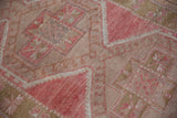 Detail of distressed Oushak rug runner highlighting geometric pinwheel and latch motifs in dusty pink and golden sage.