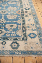 Distressed blue Oushak rug edge showing intact side cord selvage and floral border.