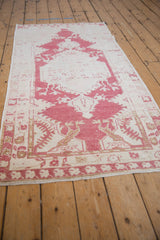 Distressed Oushak runner texture with pale cochineal red, ivory field, and visible foundation.