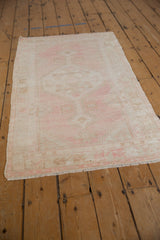 Textured pile, secured side, and delicate fringe of a distressed Oushak rug in pale pink.