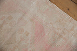 Distressed texture of the Oushak runner, showing worn pile with ivory and pale pink hues.