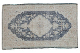 Distressed vintage Sparta rug, dusty navy blue scalloped medallion and ivory floral field.