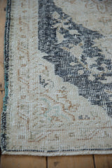 Distressed Sparta rug detail, low pile with visible foundation, dusty navy and ivory, intact selvage.