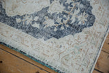 Distressed vintage Sparta rug corner detail, dusty navy floral pattern, ivory field, visible knot heads.