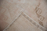 A folded corner reveals the durable hand-knotted foundation beneath the distressed, low-pile surface.