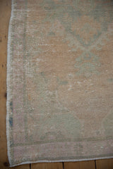 Close-up of the distressed Oushak rug's intact side cord and low, evenly worn pile.