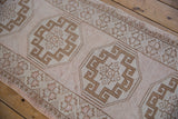 Vintage Oushak rug detail: distressed ivory and coffee brown geometric gul design with rams horn contours.