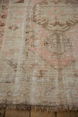 Distressed blush and coffee brown pile of the vintage Melas rug, showing wear and fringe.