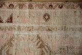 Worn pile texture of a vintage Melas rug, revealing coffee brown and blush motifs.