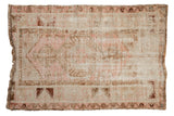 Pink and ivory distressed Melas rug with central medallion, ram's horn finials, and geometric blossoms, 3'3