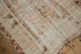 Worn pink and antique ivory Melas rug showing exposed foundation and faded brown geometric designs.
