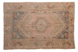 Distressed vintage Melas rug, blush medallion, faded slate blue corners, geometric patterns. 3'6