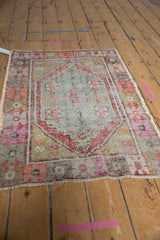 Distressed Oushak rug showcasing its stepped medallion and lively time-softened colors.