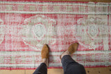 Distressed Oushak runner texture, showing cherry red, beige, ivory and roundel patterns.