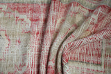 Distressed red and ivory Oushak rug pile showing visible wear to foundation.