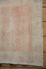 Corner detail of the distressed vintage Oushak rug showing even wear and the intact side cord.