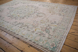 Distressed vintage Oushak rug corner, pale pink field, seafoam green spandrel, intricate palmettes.