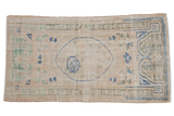 Distressed vintage Oushak rug runner with ivory field, cobalt blue medallion, and green floral vines.