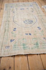 Distressed Oushak runner detail: low pile, faded ivory, cobalt blue, and pale green blossoms.