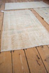 Distressed vintage Oushak runner texture with worn pile, faded floral vinery, and visible foundation.