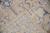 Close-up of vintage Oushak rug's worn pile, exposed foundation, and beige, ivory, blue colors.