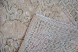 Close-up of the Vintage Oushak rug, showing distressed pile and hand-knotted foundation.