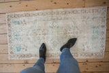 Decorative vintage Oushak runner with soft ivory, brown, and dusty turquoise distressed texture.