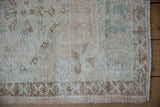 Distressed Oushak runner's worn pile texture with faded ivory, rose, coffee, and turquoise.