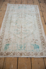 Distressed vintage Oushak rug runner with worn texture, faded ivory, and soft turquoise patterns.