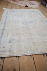Distressed vintage Turkish Oushak rug, showing worn ivory pile and faint cobalt blue patterns.