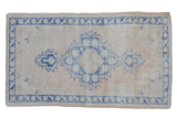 Vintage Distressed Oushak rug with faded cobalt blue geometric medallion and worn ivory field.