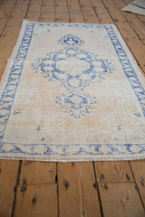 Hand knotted distressed Oushak rug with faded pale cobalt blue patterns and ivory field.