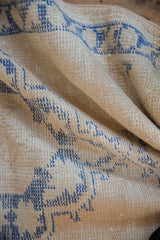 Distressed vintage Oushak rug, showing coarse texture with ivory and pale cobalt blue patterns.