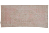 Distressed Oushak rug runner with concentric stepped medallions in pale pink, beige, and hints of cobalt blue.