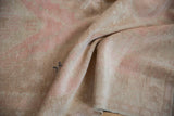 Softly worn knot heads and low pile texture on a vintage Oushak rug in pale pink and beige.