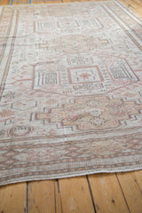 Distressed vintage Oushak rug showing worn stepped patterns in antique ivory, beige, and coffee brown.
