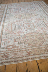 Distressed hand knotted Oushak carpet showing muted stepped and primitive floral motifs.