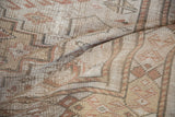 Textural surface of vintage distressed Oushak rug with worn pile, beige, and primitive motifs.