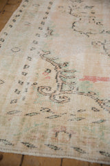 Distressed texture of the vintage Oushak rug, showing worn pile, visible foundation, and soft ivory.