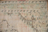 Distressed Oushak rug detail: textured ivory pile, mostly even wear with seafoam, blush tones.