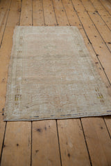 Secured end of the vintage distressed Oushak runner, showing textured beige pile with foundation.