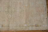 Distressed Oushak rug pile texture, with even wear revealing foundation, in muted beige.
