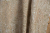 Distressed vintage Oushak rug surface, showing mostly even wear and varied beige-ivory tones.