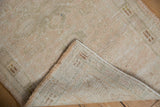 Distressed vintage Oushak runner pile and woven foundation revealed in a corner view.